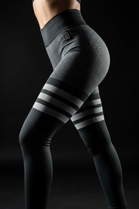 Gray leggings with black and white striped design on a plain background